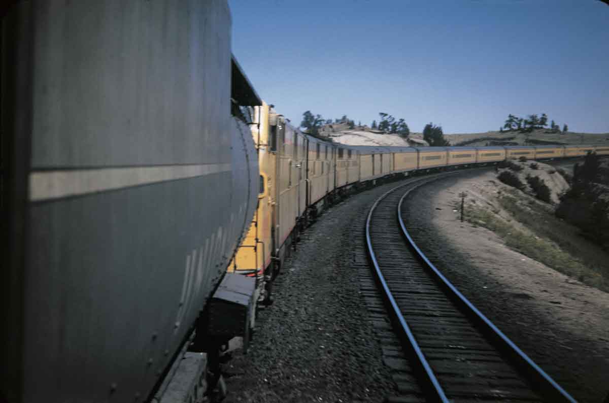 Yellow passenger train on curve as seen from lead locomotive