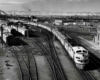 Four diesel locomotives lead passenger train out of station