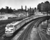 Diesel powered streamlined passenger train on elevated trackage in city