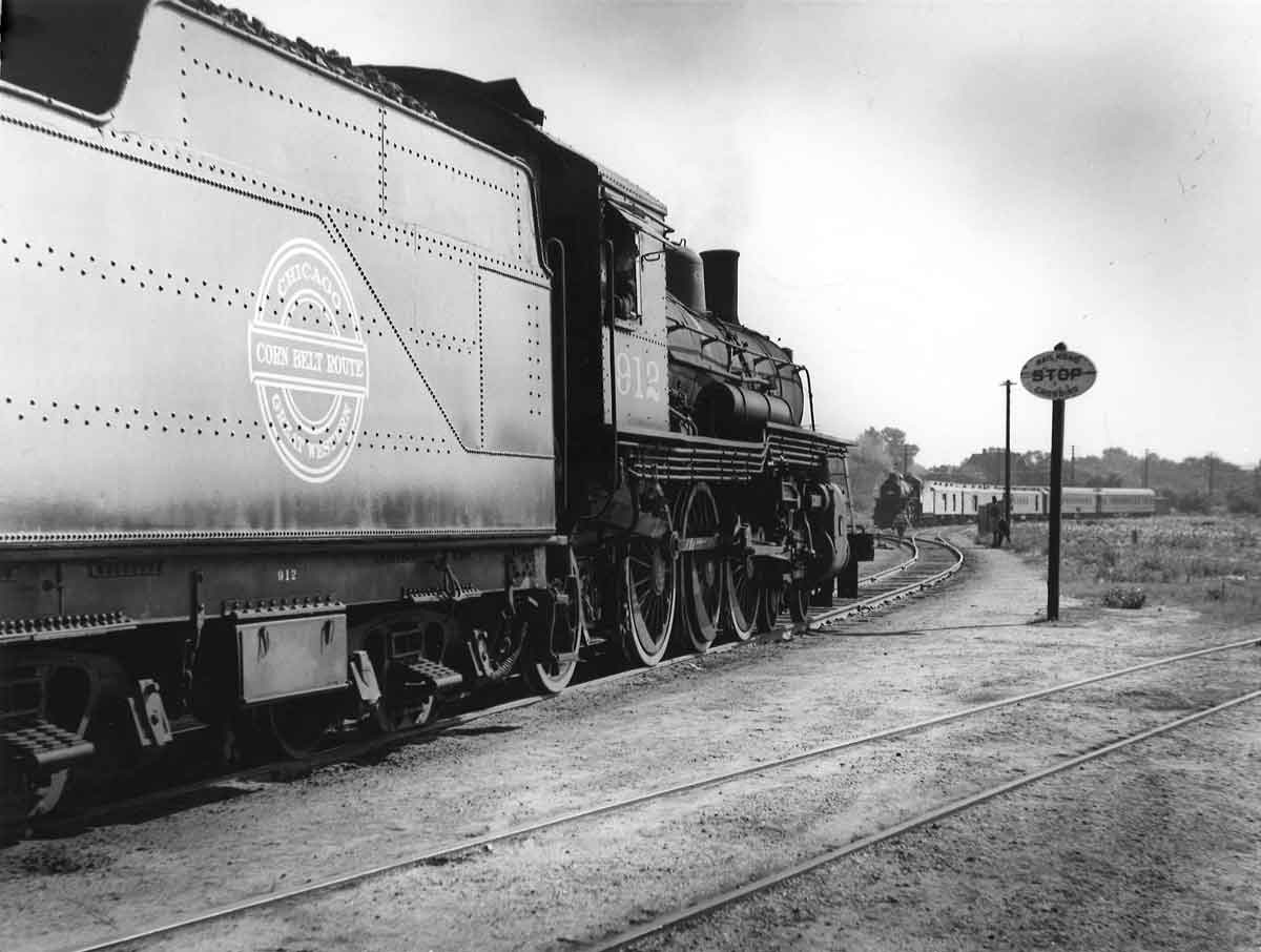 A black and white photo of two trains approaching each other