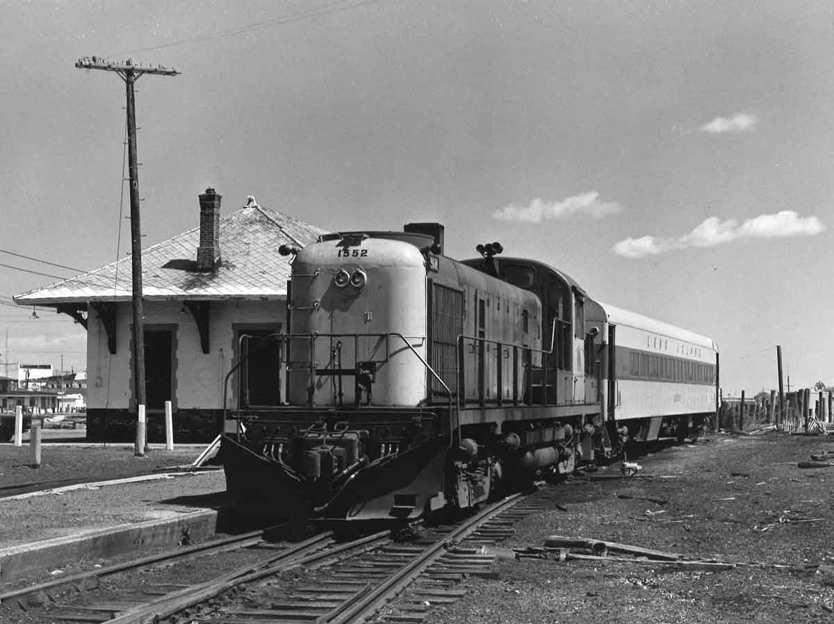 a diesel locomotive and a coach car at a station