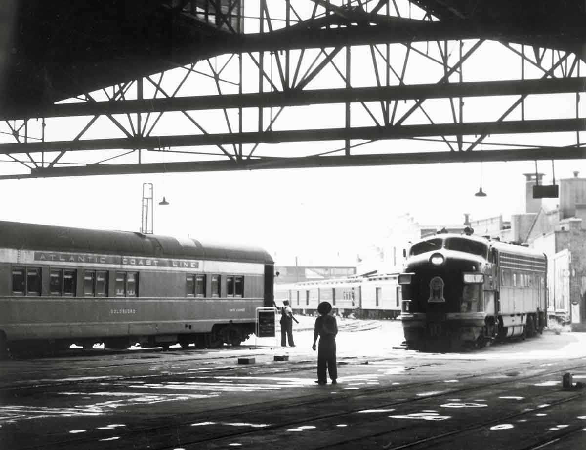 a diesel passenger train pulling into a train station