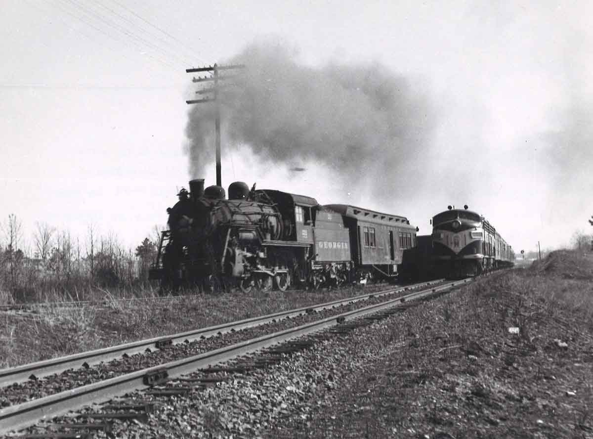 a diesel and steam engine passenger trains side by side