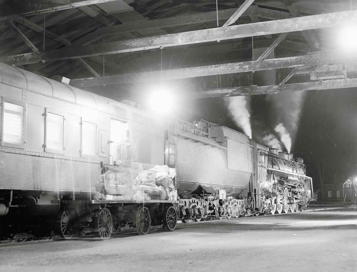 Steam powered passenger train under train shed