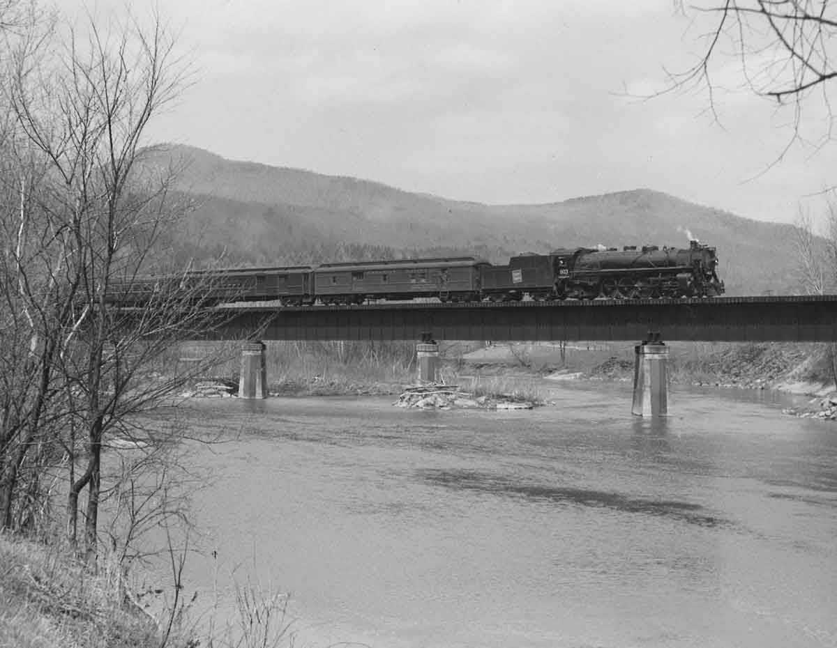 Steam locomotive with passenger train on bridge