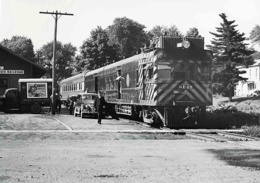 Motorcar with coach at station