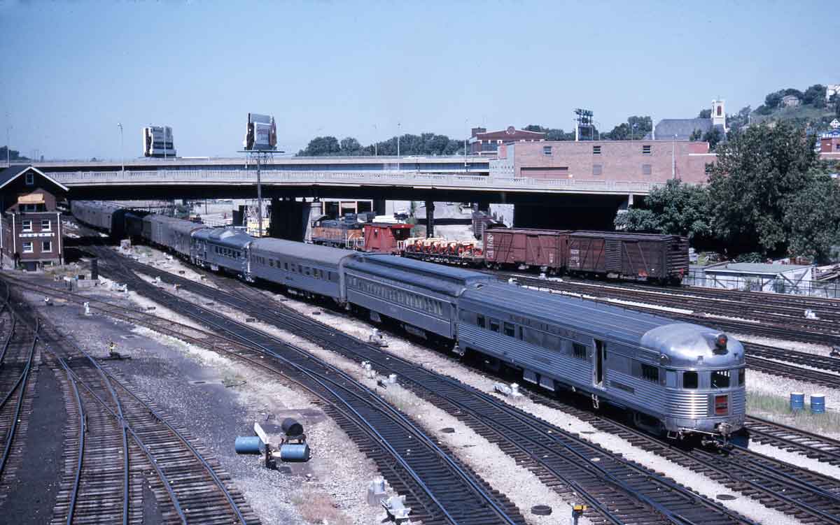 A silver train departing a station