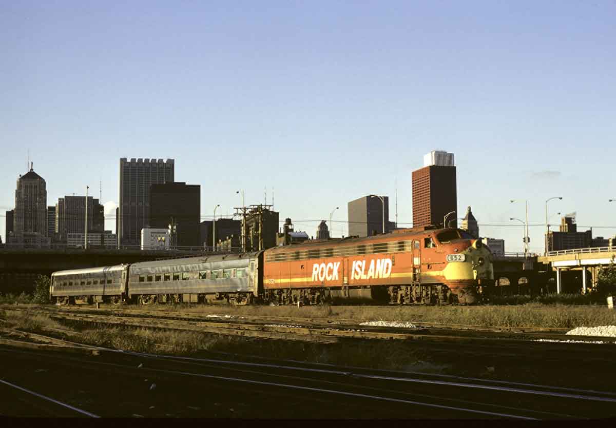 An orange and yellow train passing through Chicago