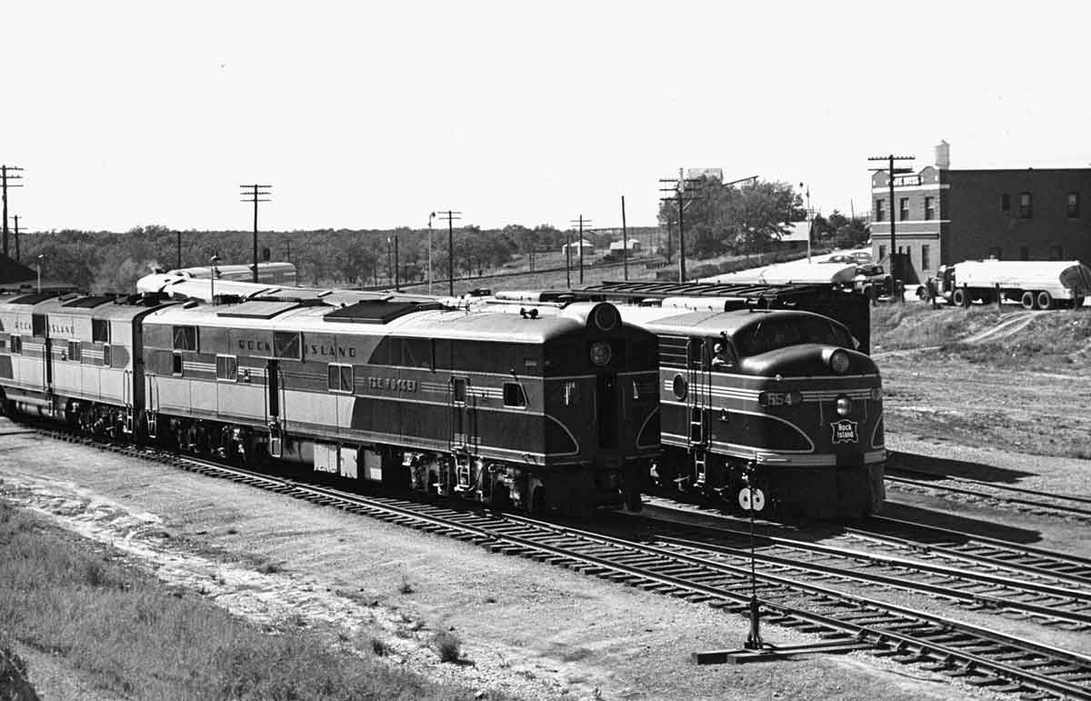 A black and white photo of two trains side by side
