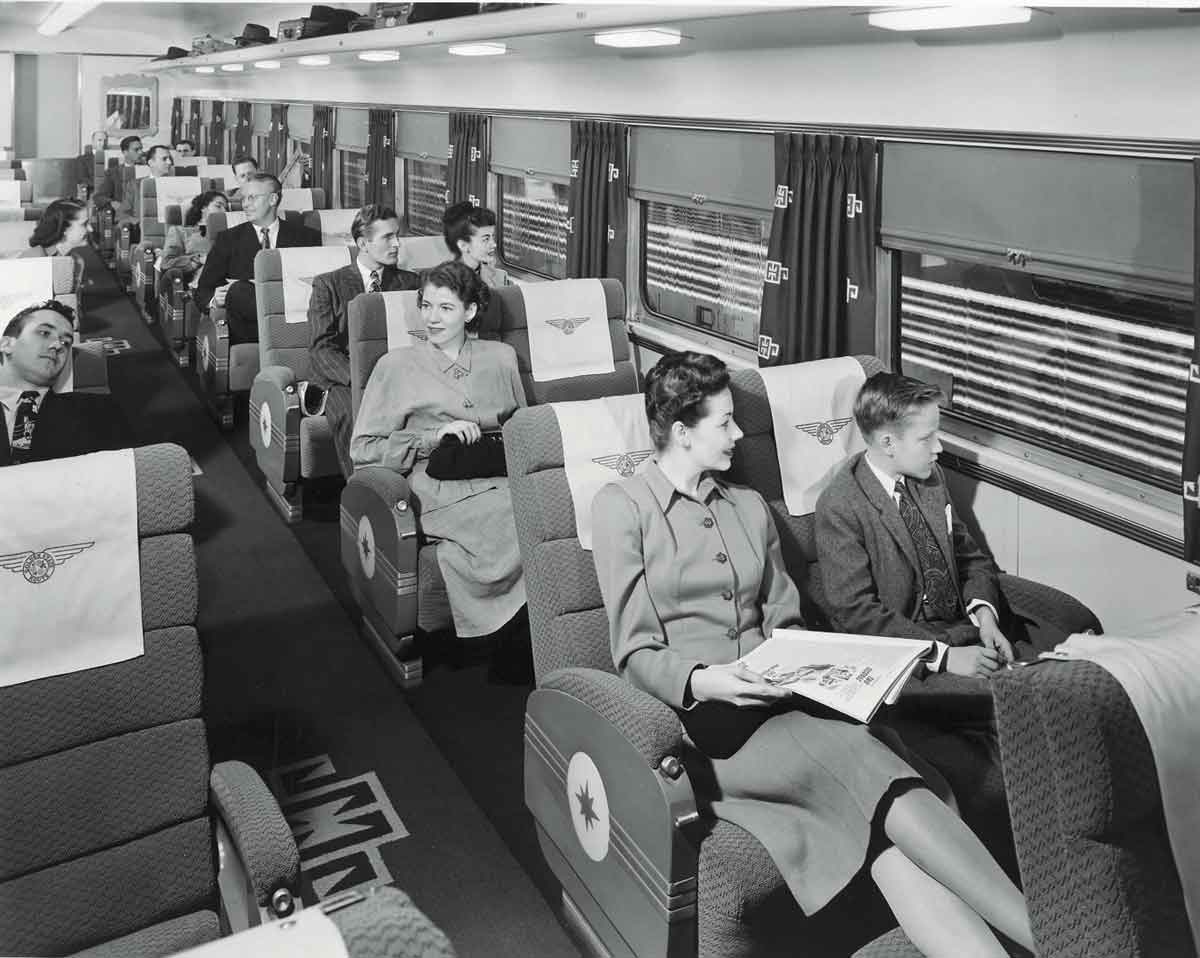 A black and white photo of passengers sitting in a train