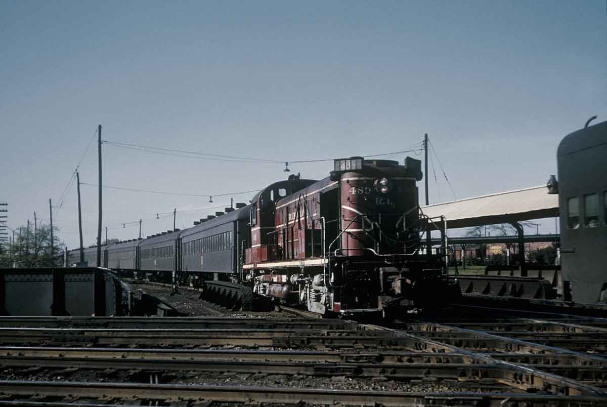 A red train approaching an intersection