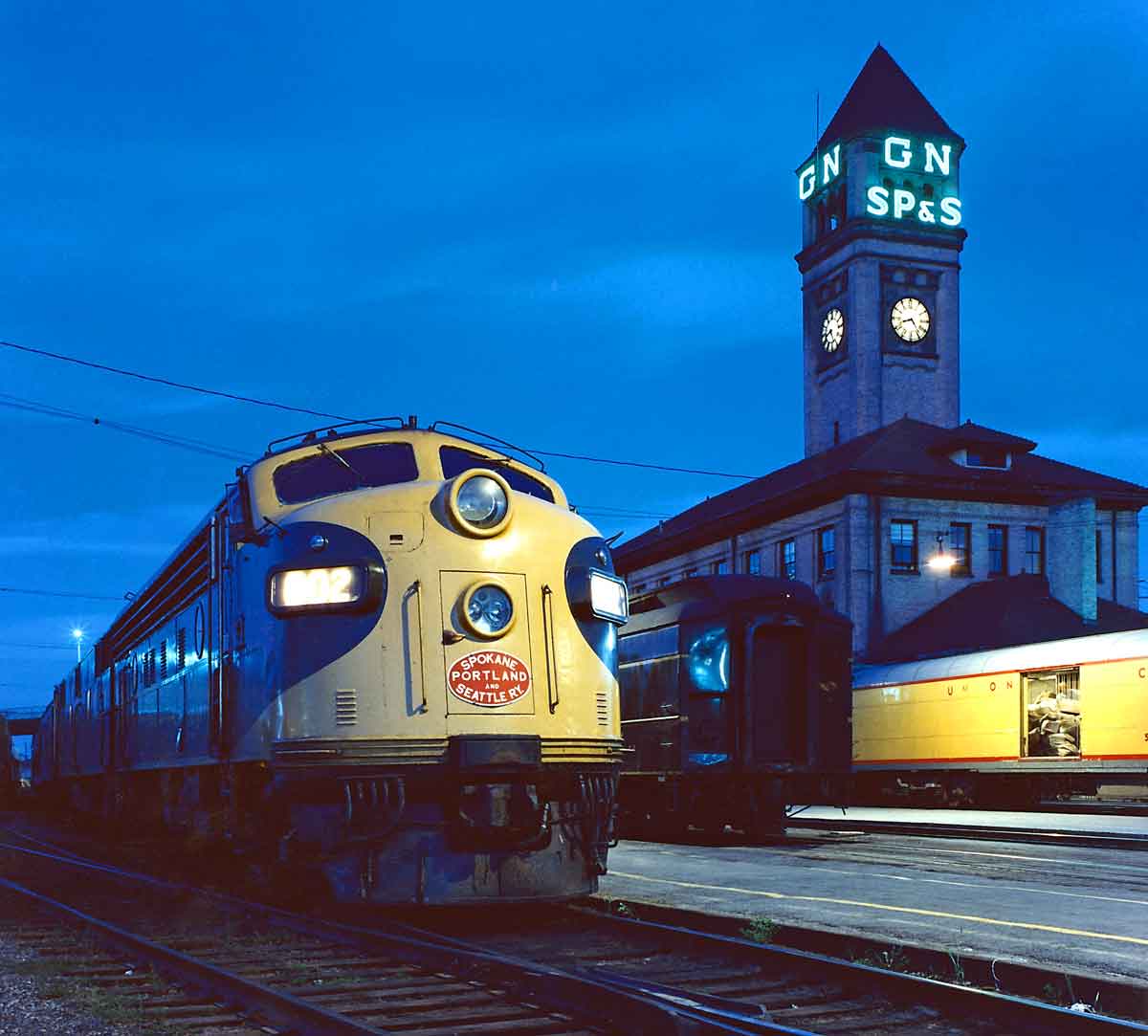 Two diesel locomotives in front of a train station