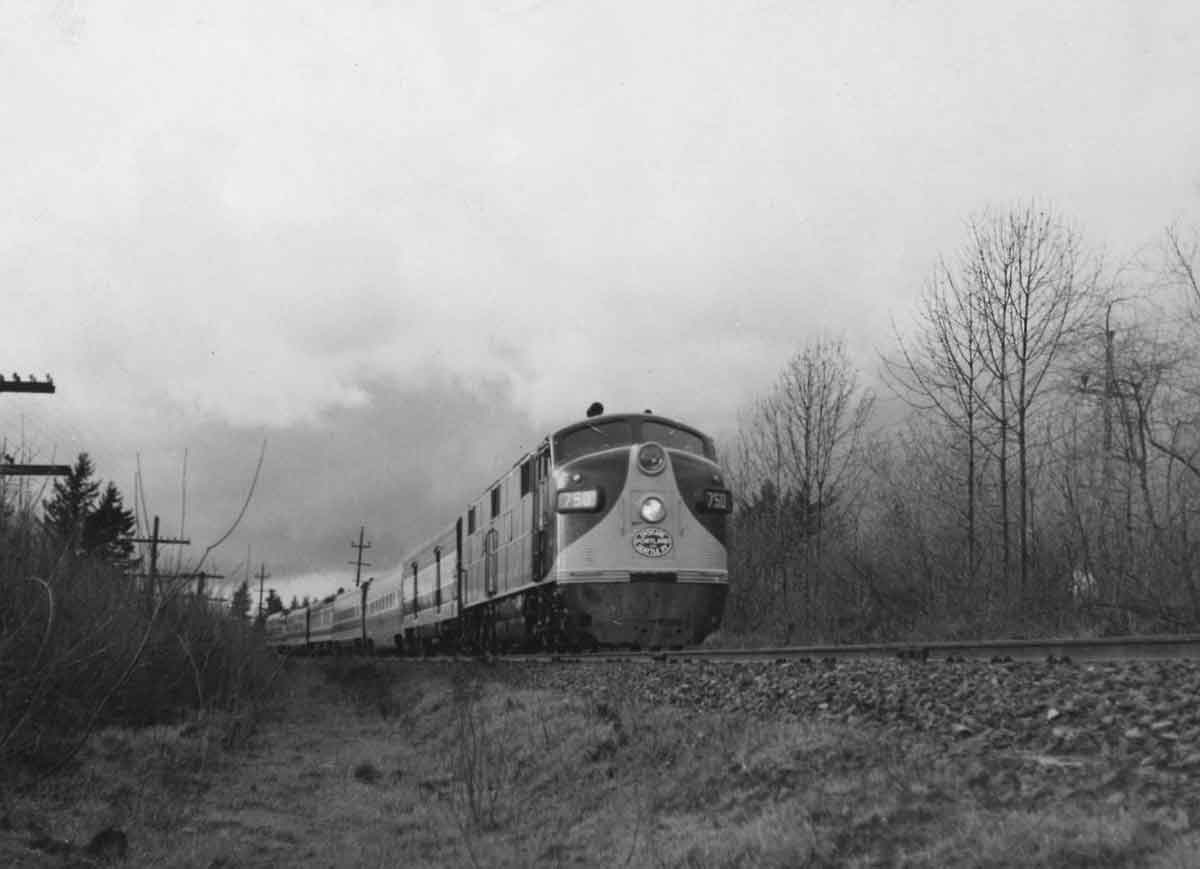 A black and white photo of a passenger train on a gloomy day