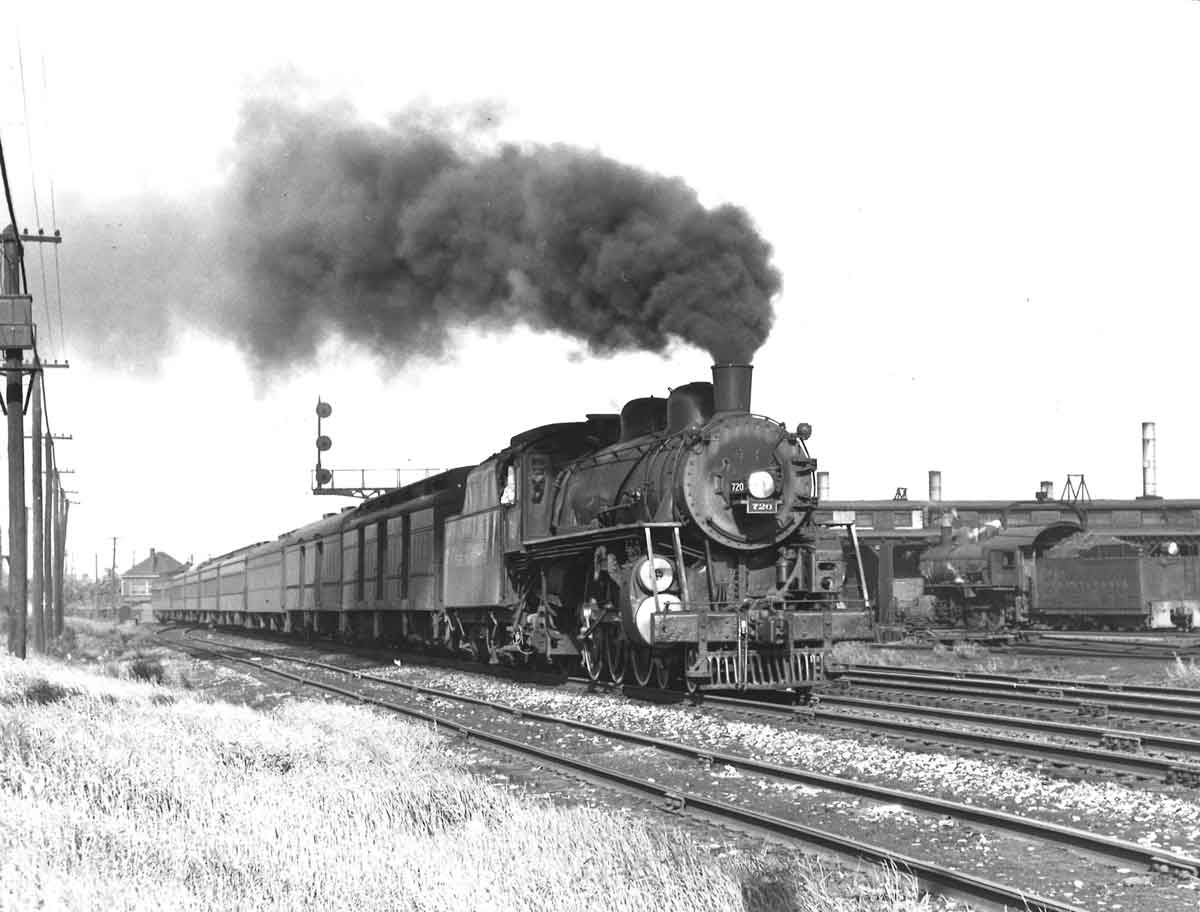 A train traveling by with black smoke coming out
