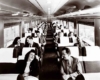 A black and white photo of passengers sitting in a train