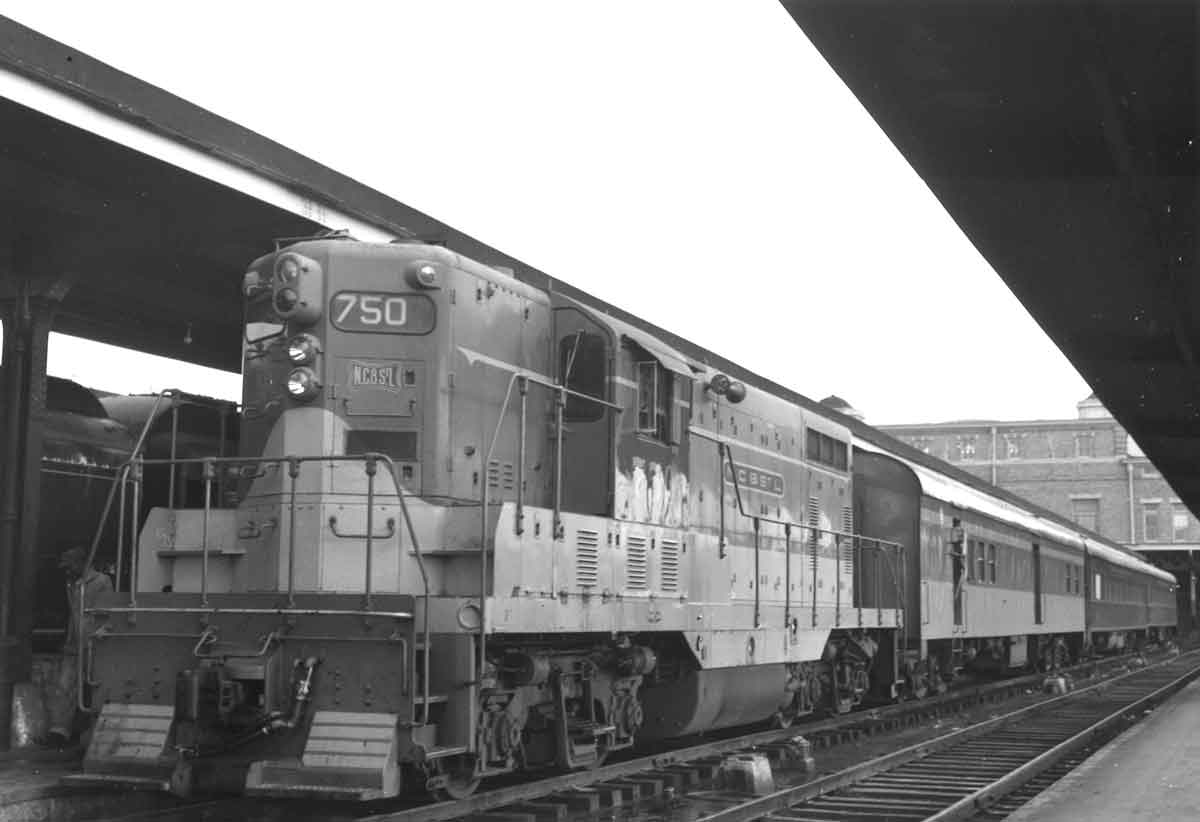A black and white photo of a train parked at a station