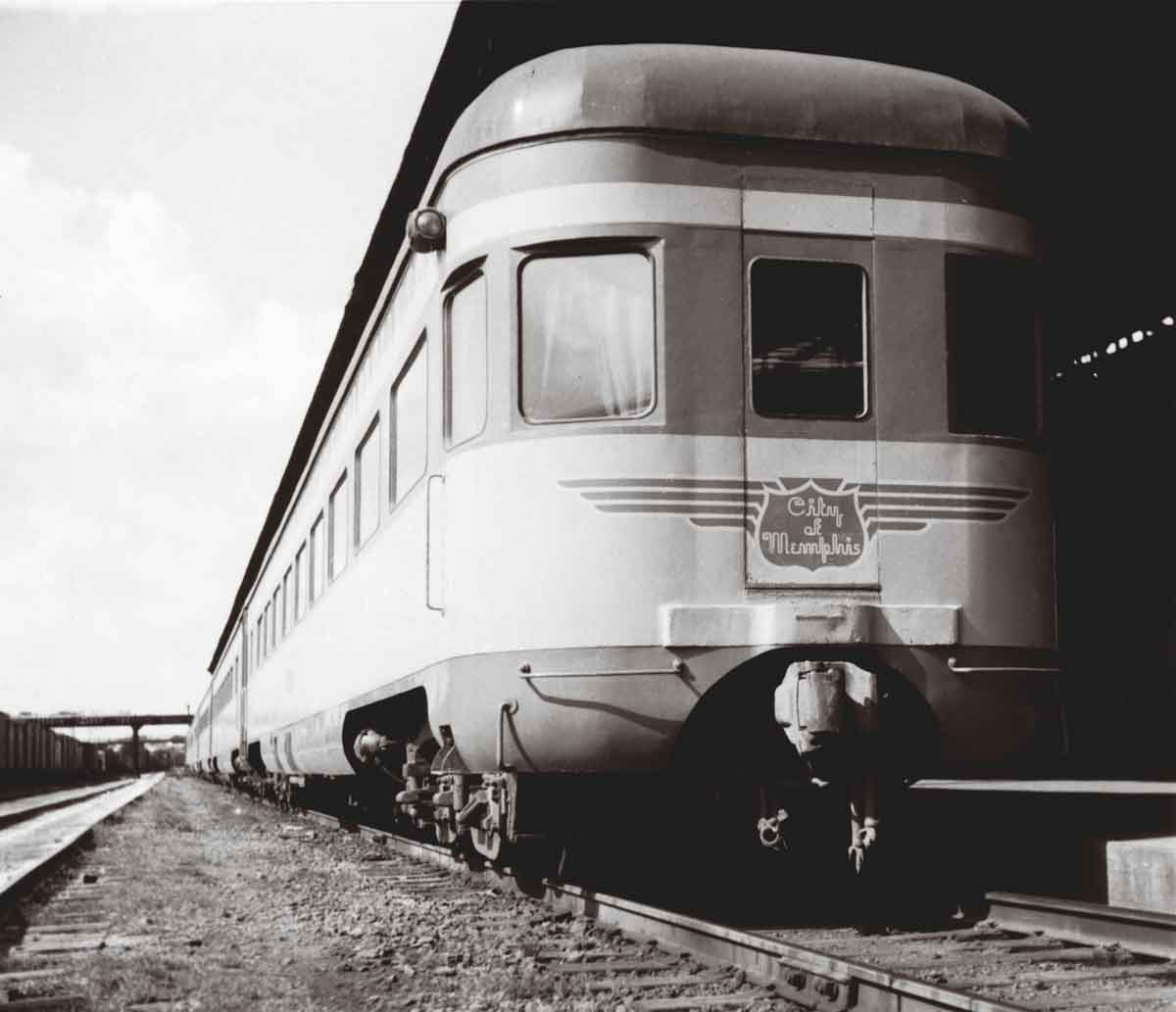 A black and white close up picture of a train parked outside a station