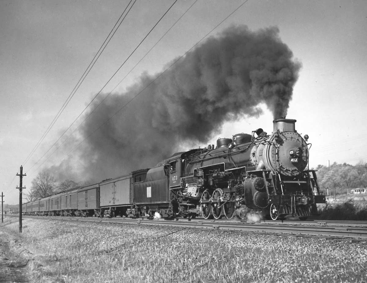 Smoking steam locomotive on passenger train