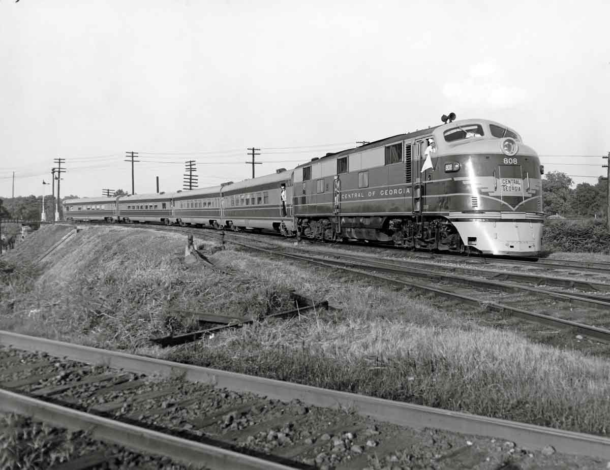 Diesel locomotive with four passenger cars on elevated curve