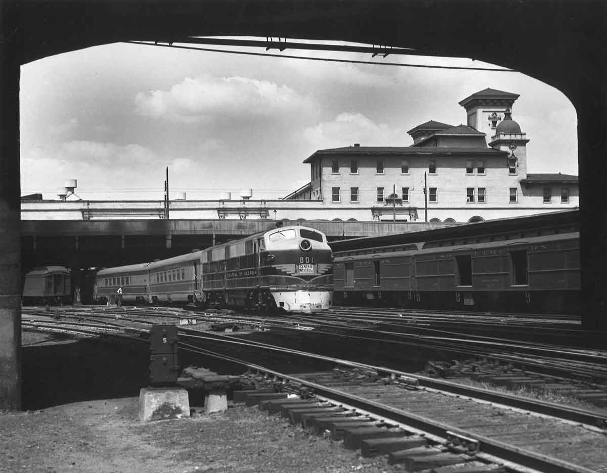 Diesel powered passenger train departing elevated station