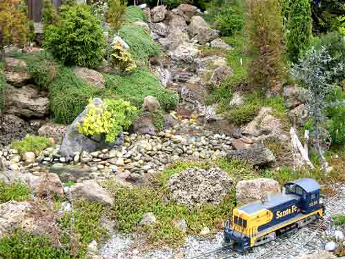 pondless waterfall with model train in front on garden railway