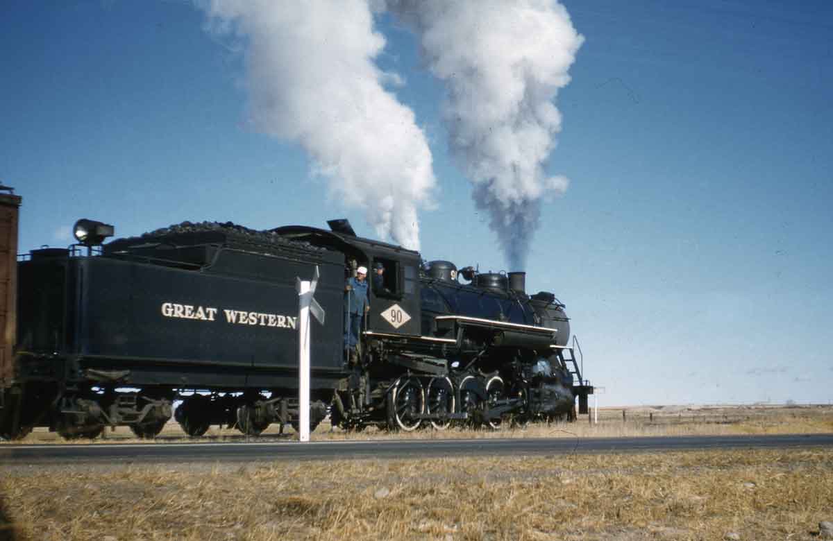 A train passing by with two guys looking out the window of the train