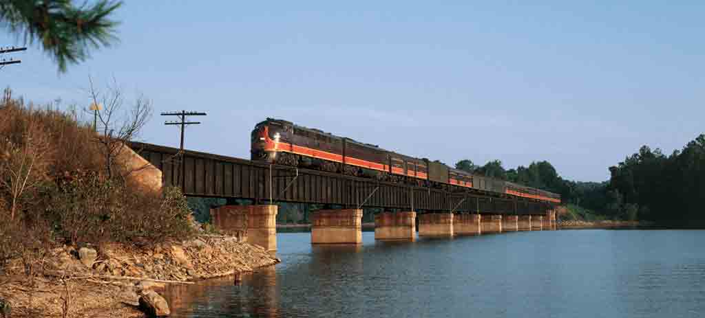 a diesel passenger train on a bridge crossing water