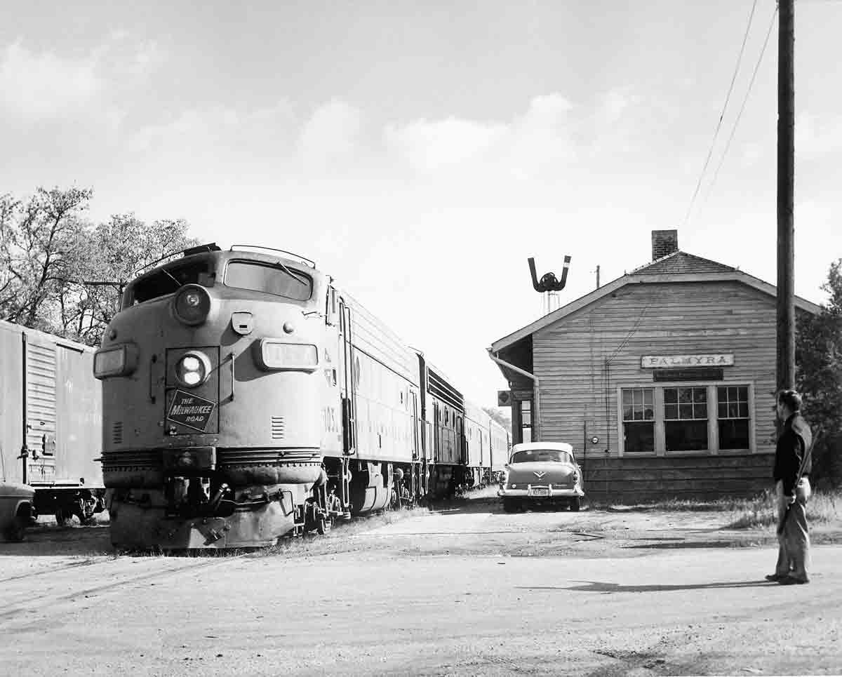 Passenger train by wooden station