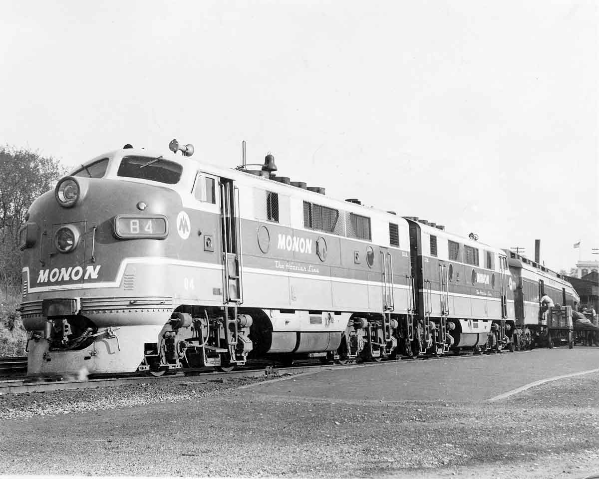 Baggage is loaded while a passenger train waits in a station