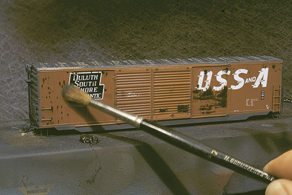 Add rust spots. Dab on dots of Burnt Umber oil paint to simulate rust spots. Next, use a soft-bristle brush to spread the “rust” downward.