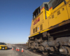 An angled photo of the big boy train with a yellow mustang car in the background