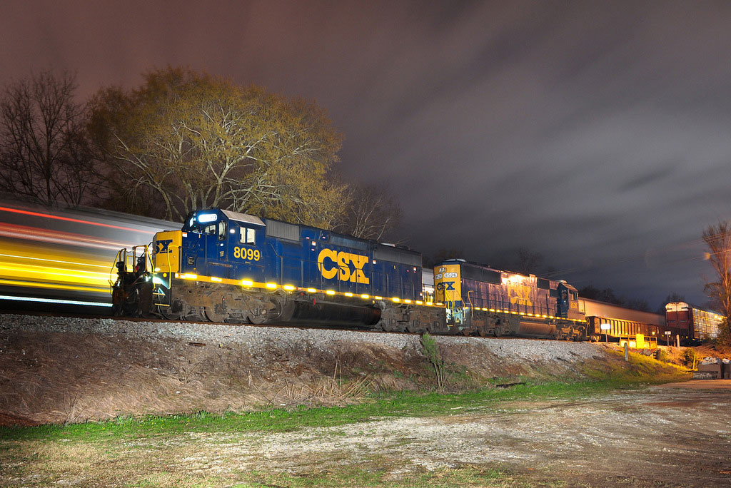 A train quickly moving by during sunset