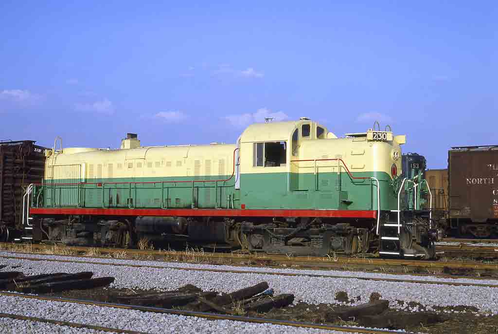 Yellow and green diesel locomotive in yard