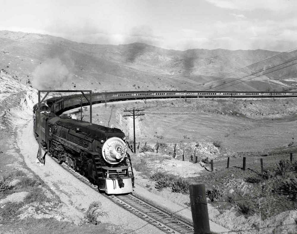 Steam locomotive with passenger train on broad curve