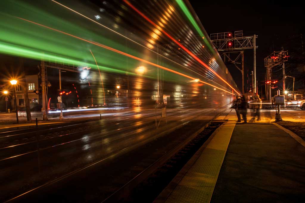 The metra speeding by after dropping off passengers in the dark