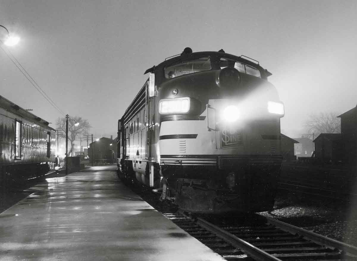Passenger train along platform on foggy night