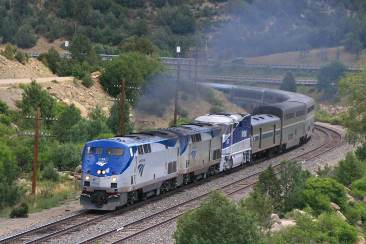 Passenger train with three locomotives rounds tight curve