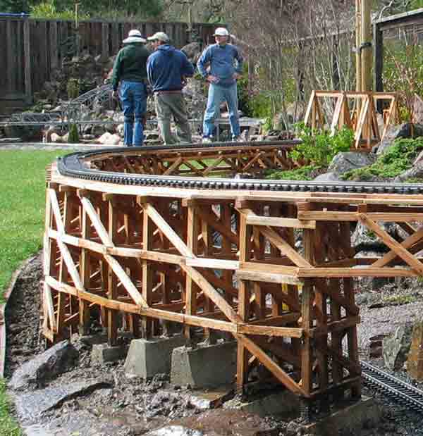 three men behind large trestle