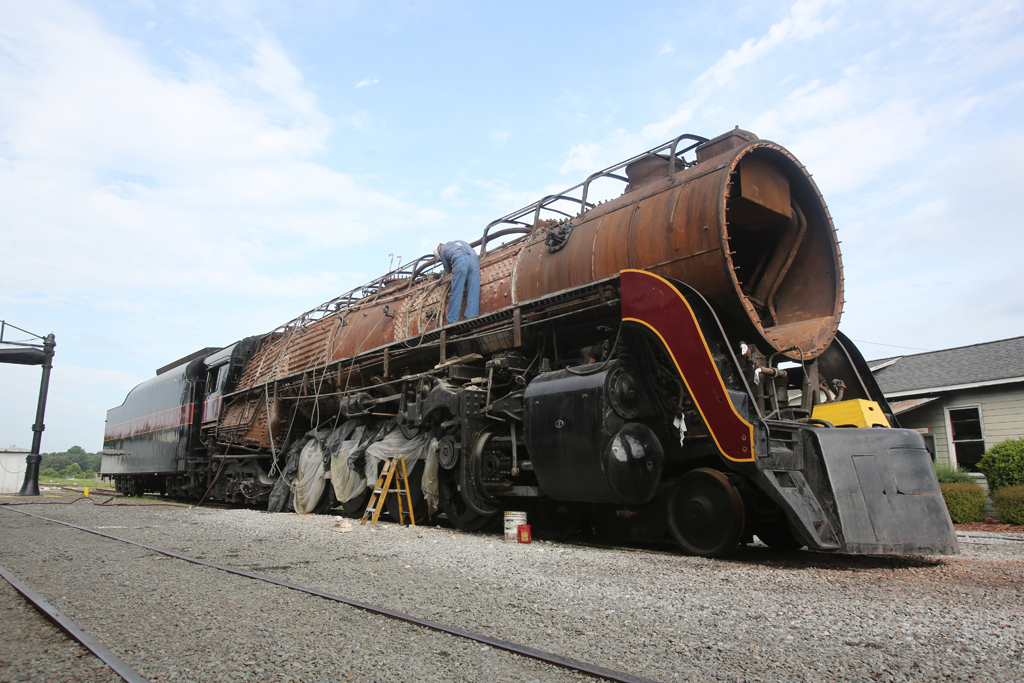 A side angle photo of a man working on a train