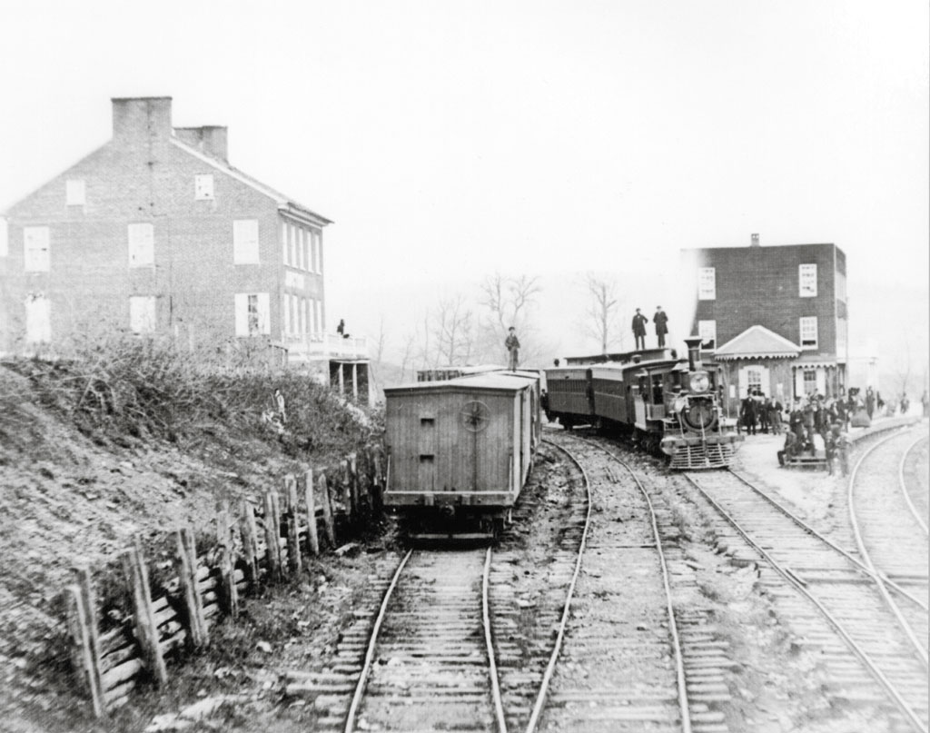 men standing on various train cars in a black and white photo