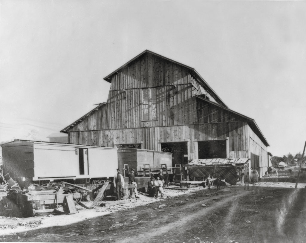 black and white building with train cars by it