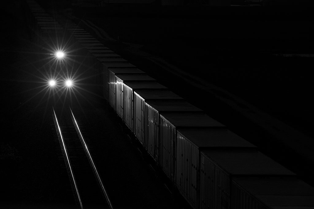 A train traveling in the dark with three headlights