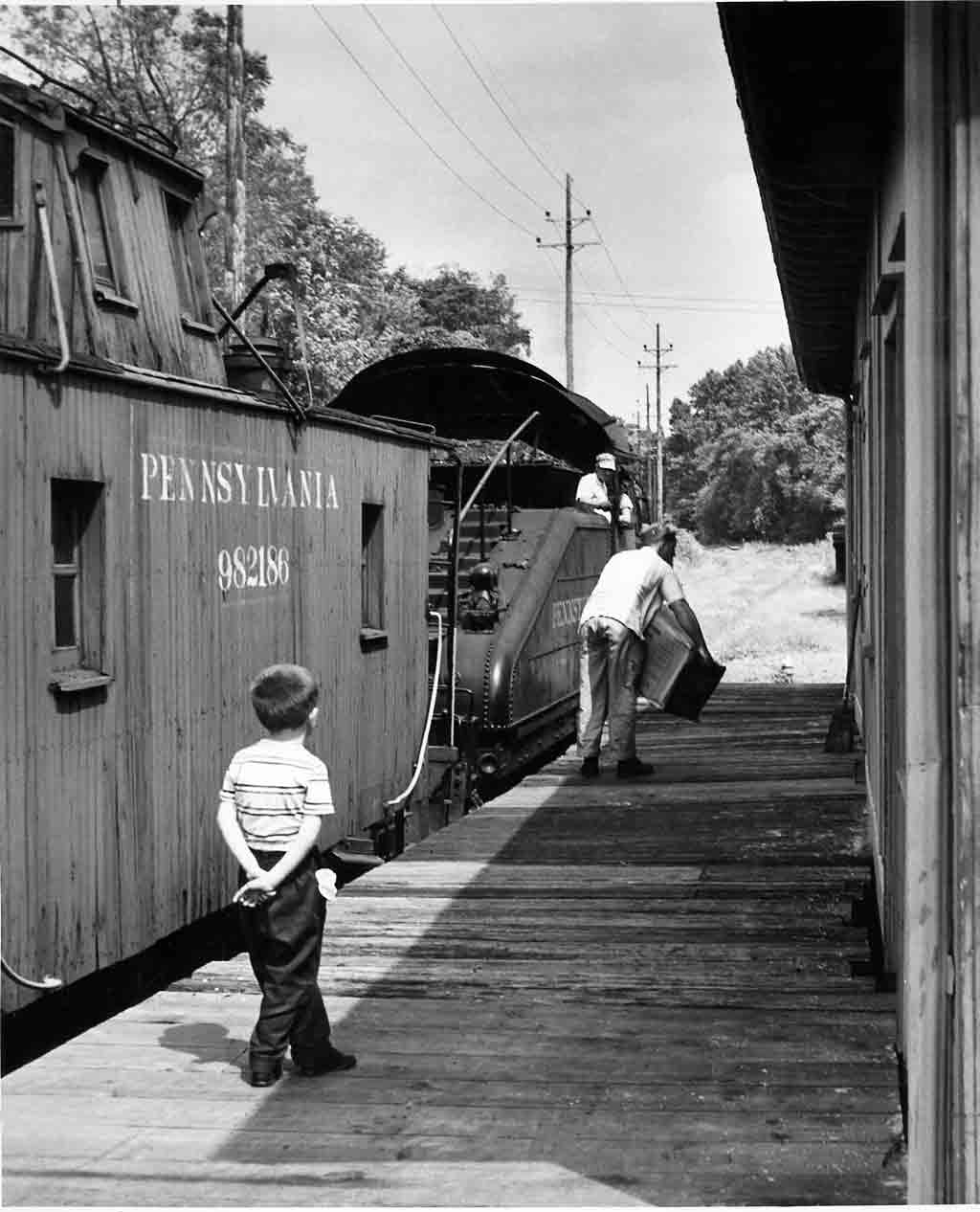 Boy watches railroaders work