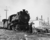 Men look over automobile in front of locomotive