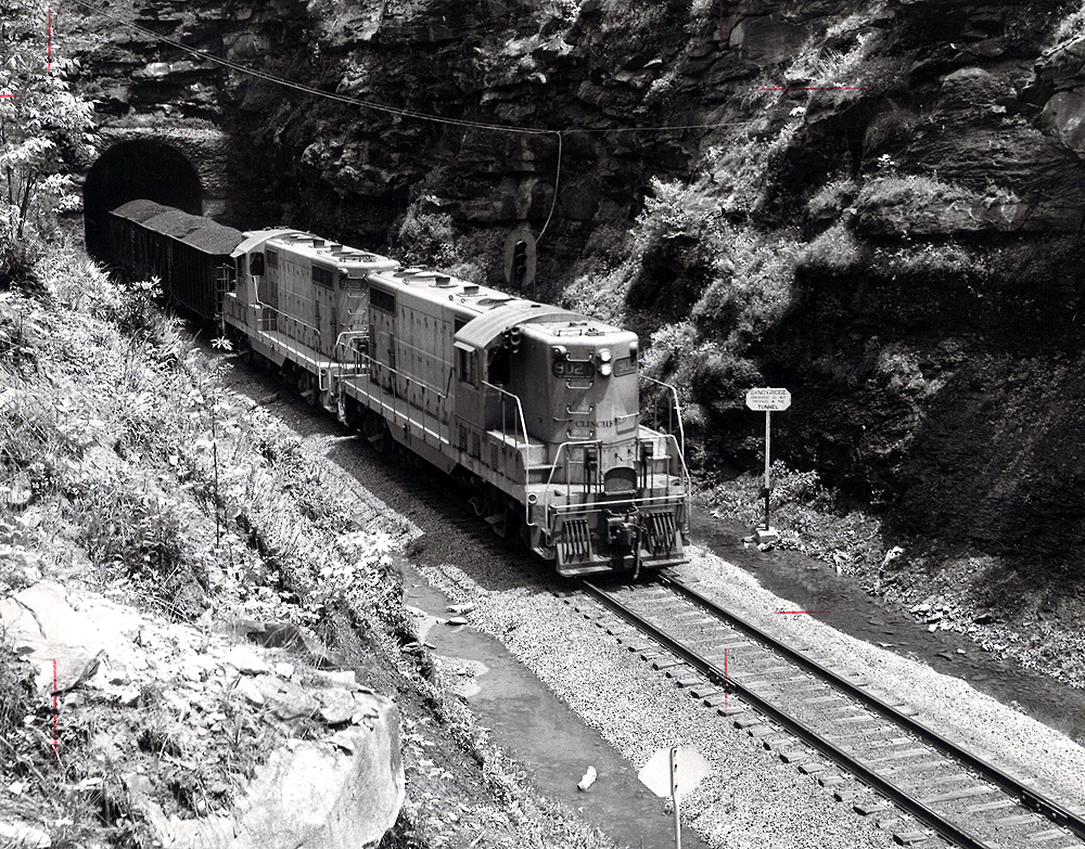 A black and white photo of GP7s 902 coming out of a tunnel