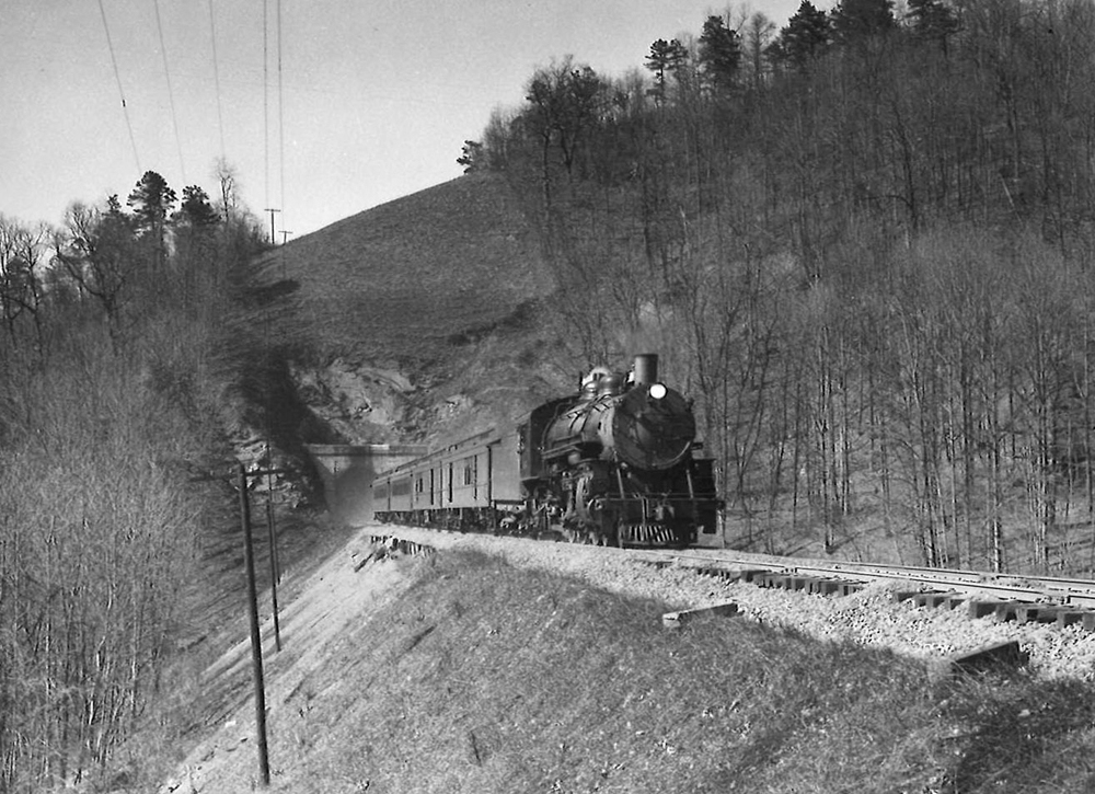 A black and white photo of Clinchfield coming out of a tunnel on a raised track