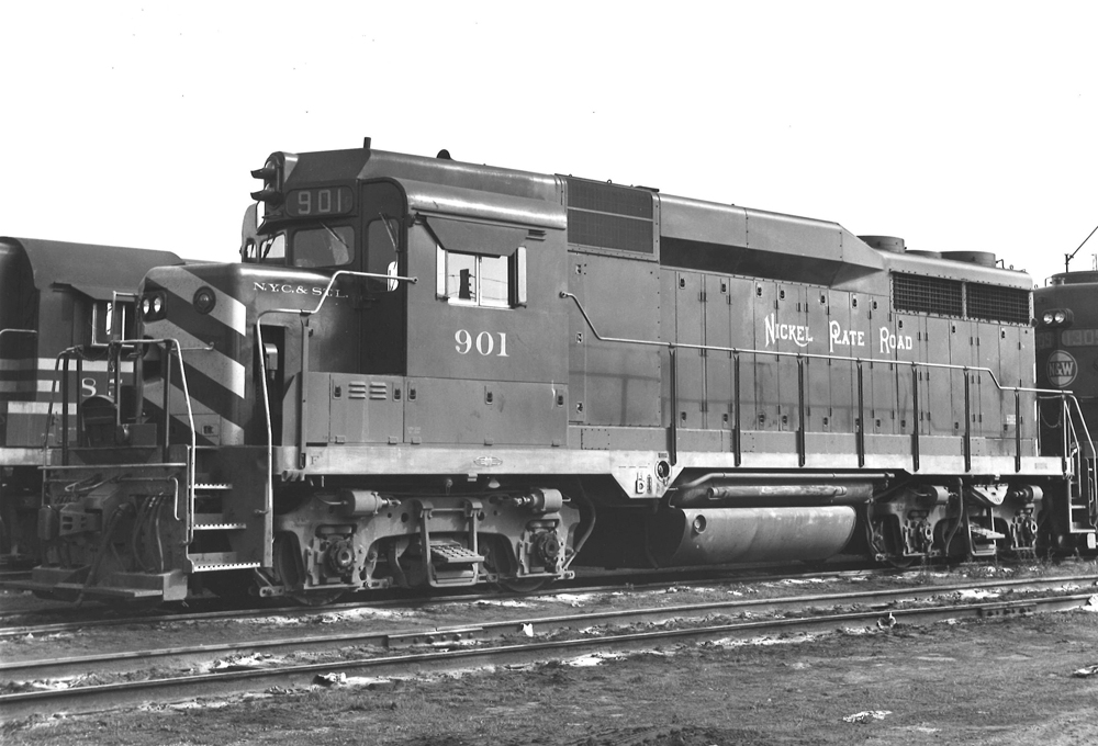 A close up black and white picture of a GP30 diesel locomotive parked in a rail yard