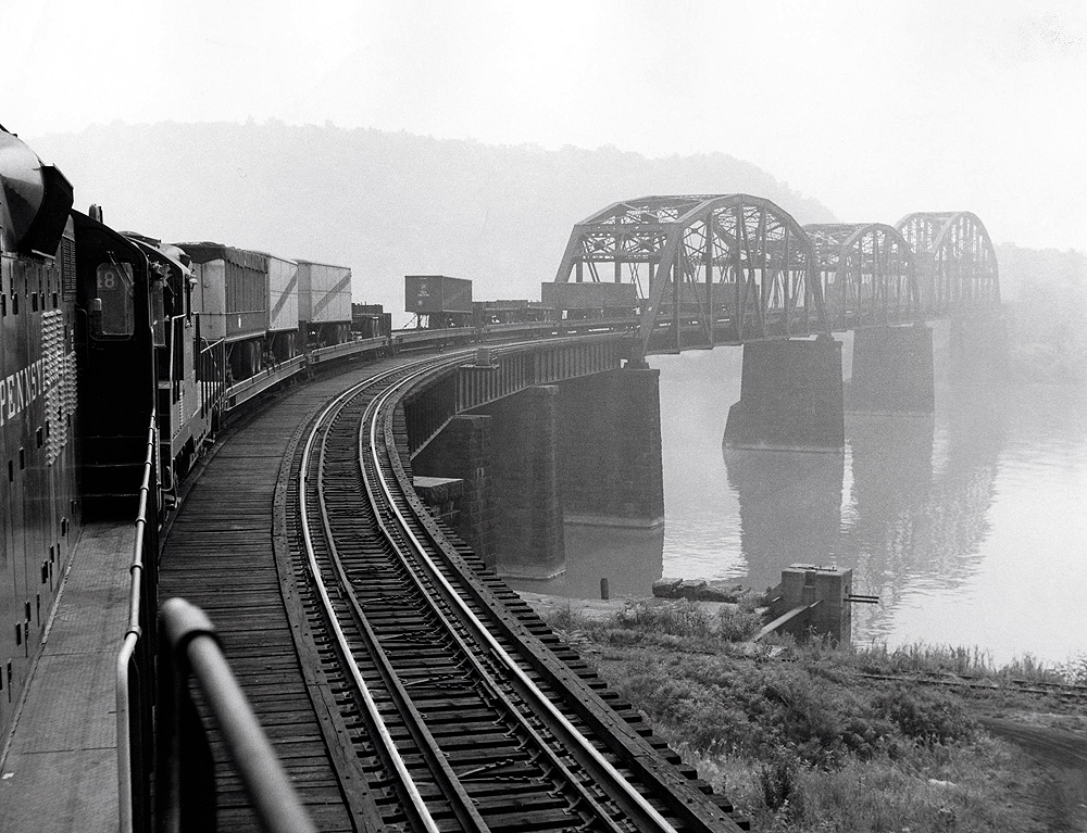 Looking back at a train passing over a bridge