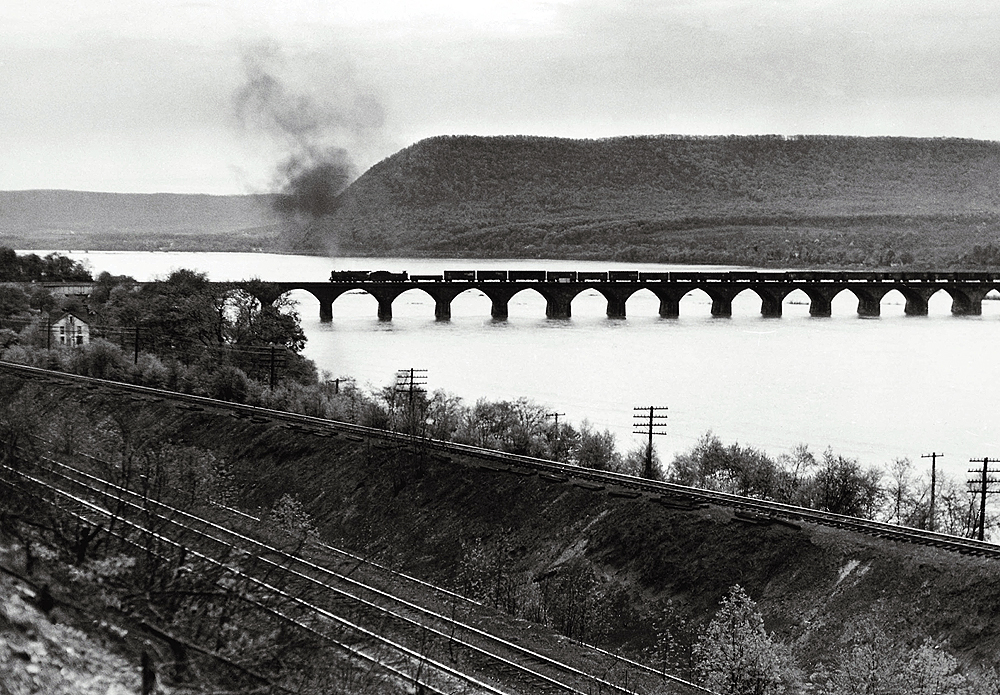 A distant shot of a train crossing a bridge