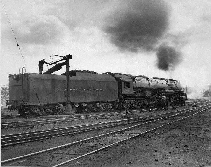 A man standing on top of a parked train